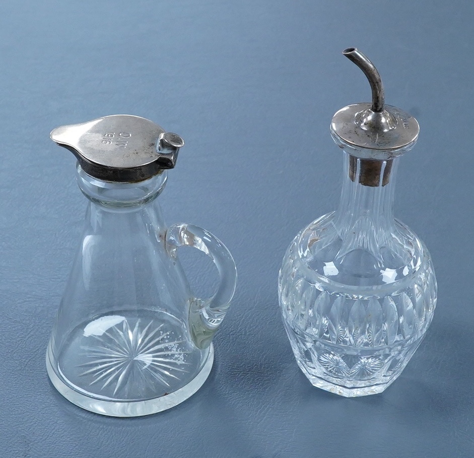 A George V silver mounted glass whisky noggin, indistinct maker's mark, Birmingham, 1913, with later engraved inscription, height 10.5cm, together with a later silver mounted cut glass oil or vinegar bottle.